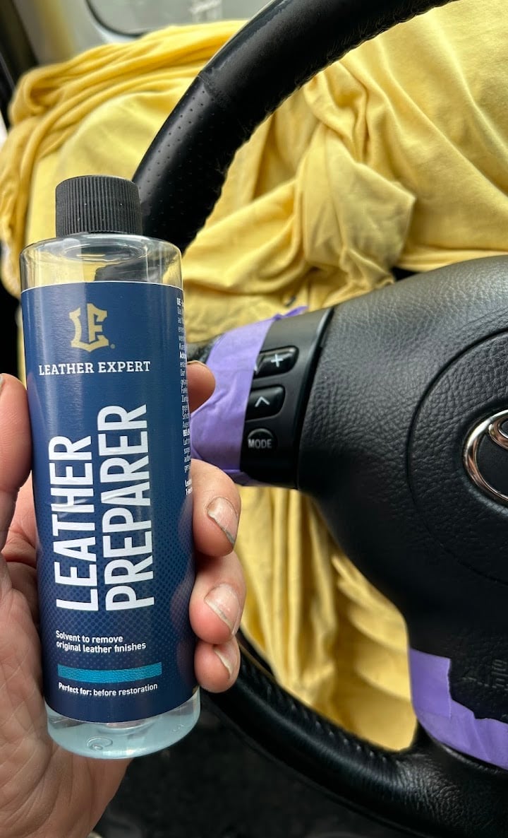 Hand holding Leather Expert cleaner inside car