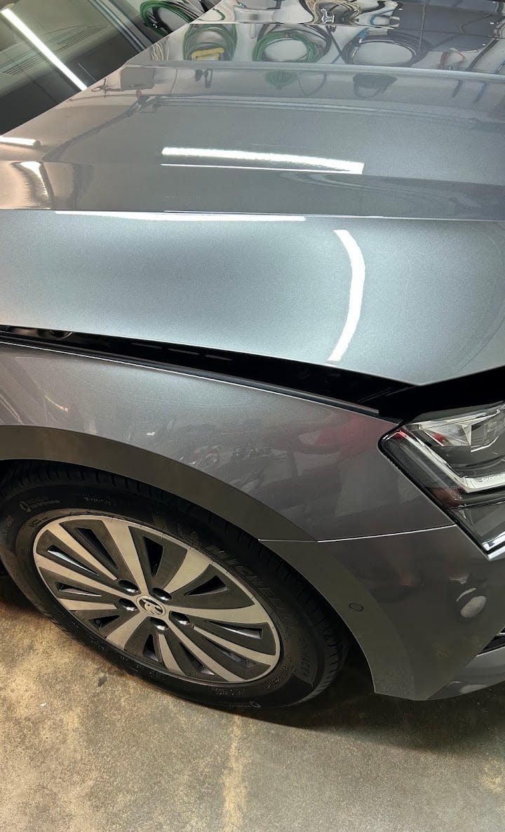 Silver car with open hood in parking garage