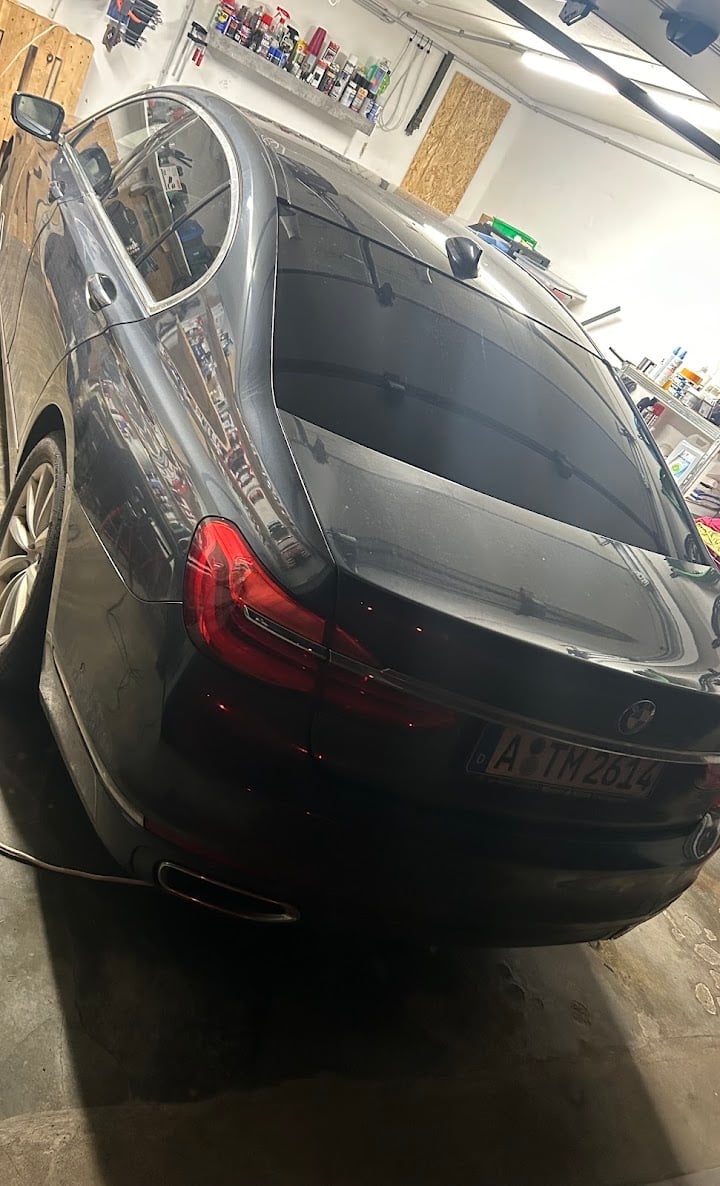 Black sedan in garage with red tail lights