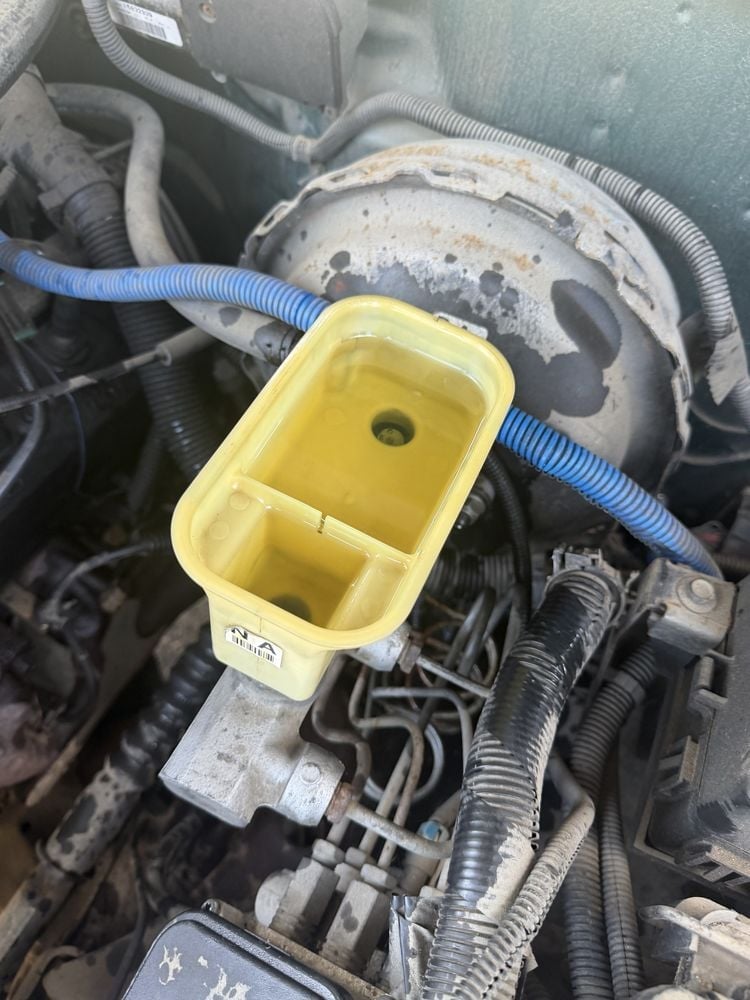 Brake fluid reservoir before service — dark contaminated fluid