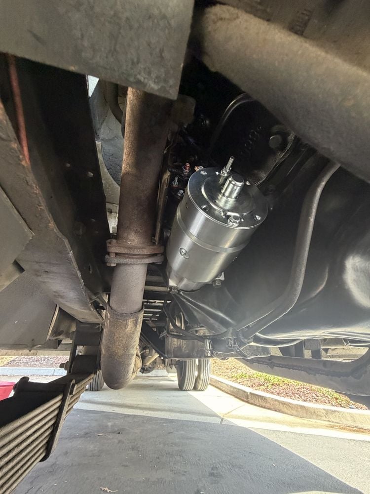 Close-up of a vehicle starter motor mounted on the engine block after replacement