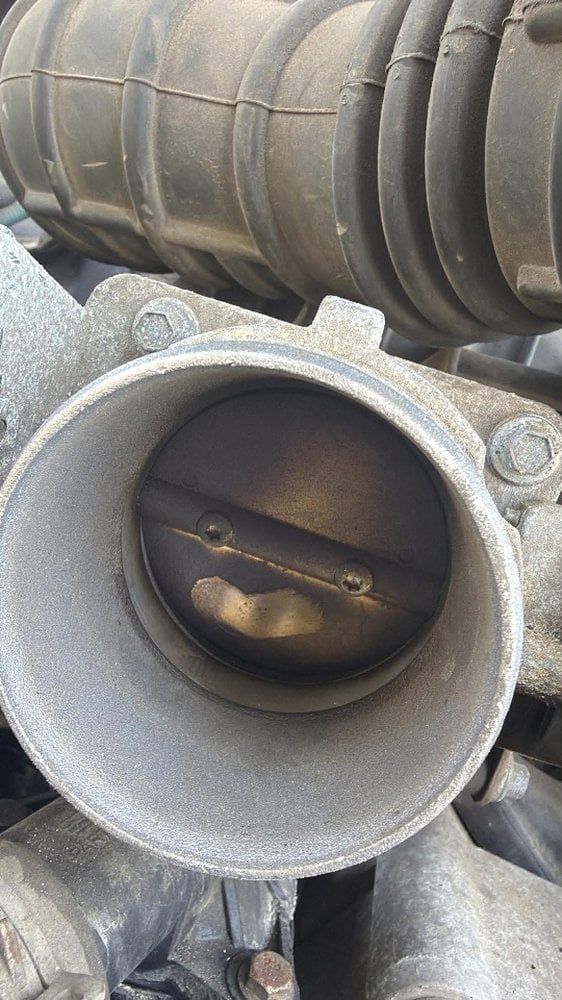 Throttle body before service — heavy carbon buildup