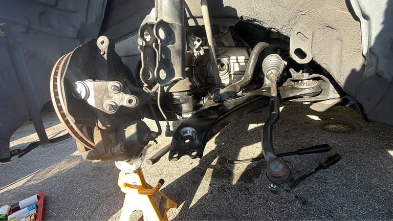 Close-up of a vehicle CV axle and suspension components during repair work