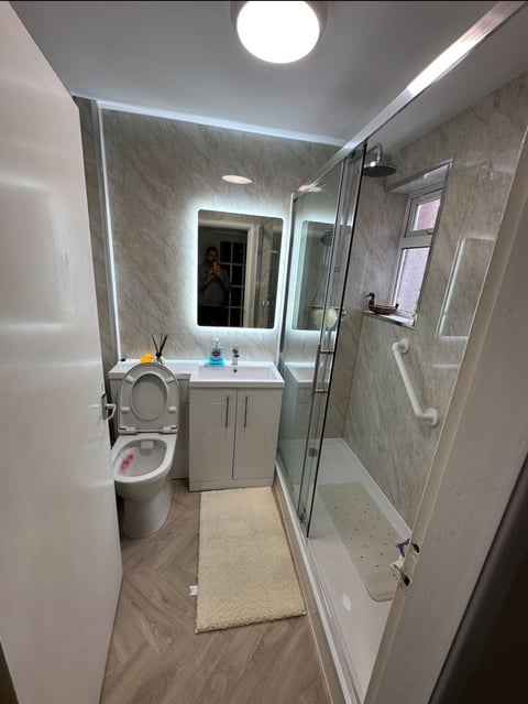 Bathroom transformation — modern suite with vanity, mirror and glass shower