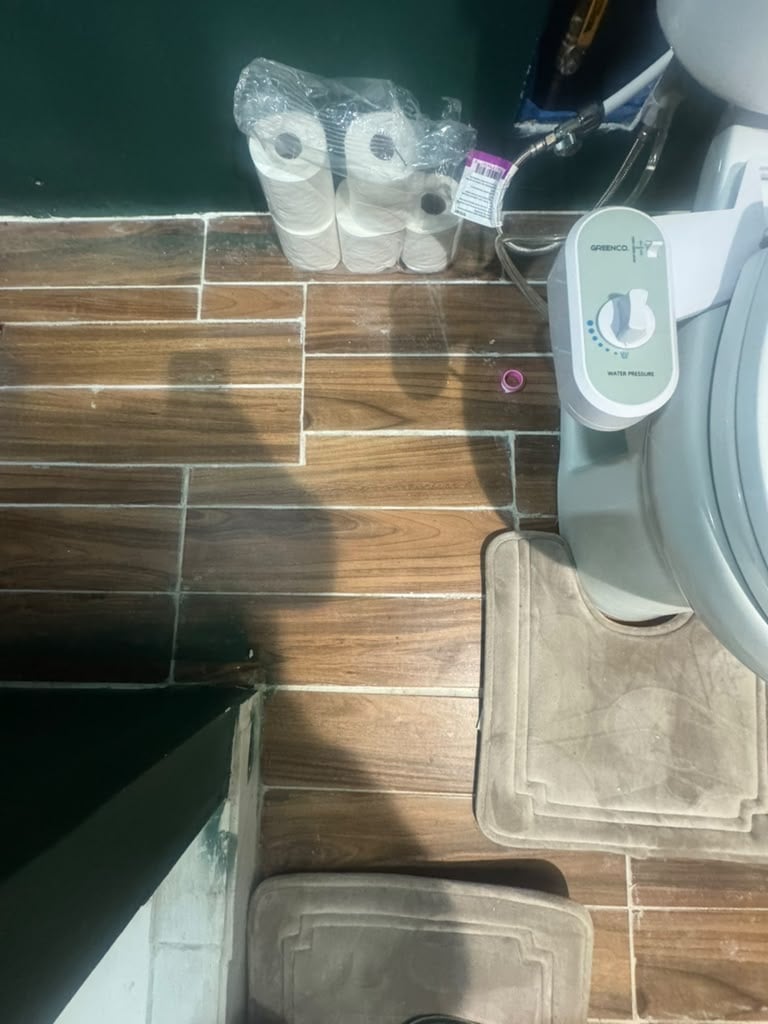 Overhead view of boat deck with paper towel rolls, white motor/electrical equipment, and wooden flooring with water visible