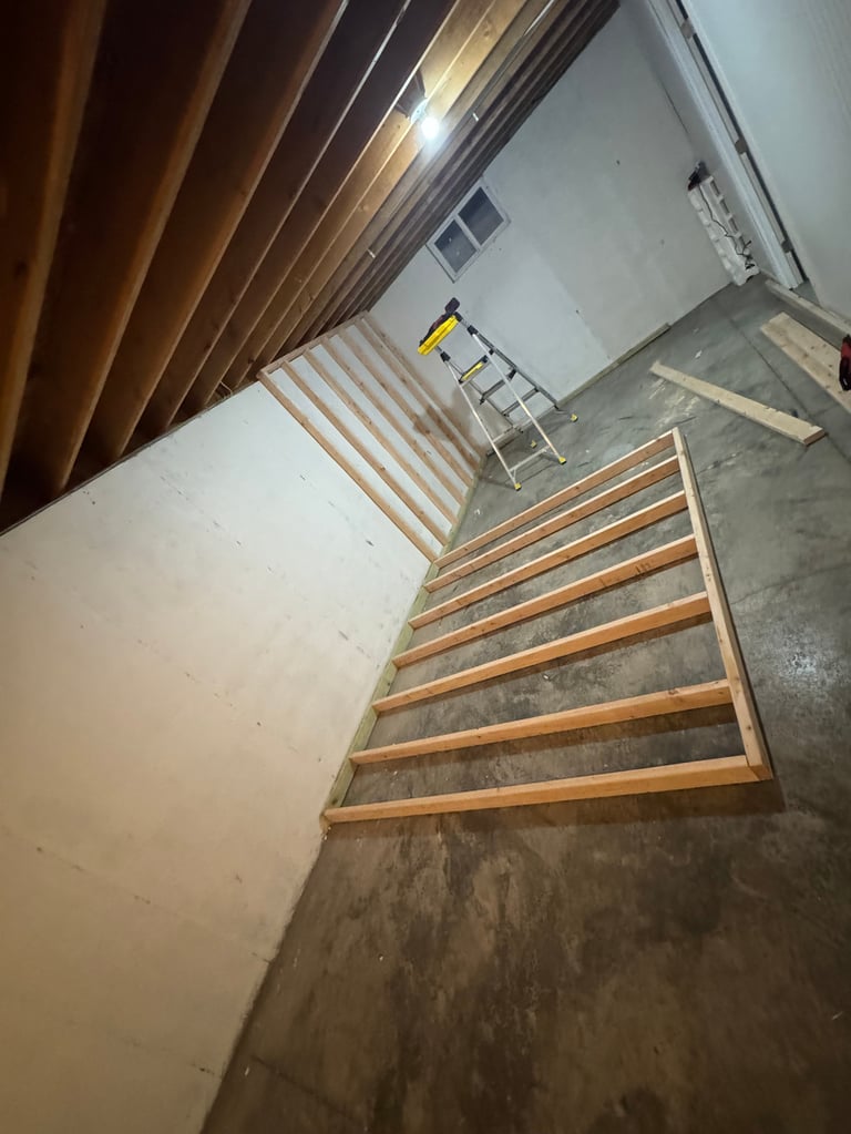 Wooden bed frame assembly on concrete floor in unfinished room
