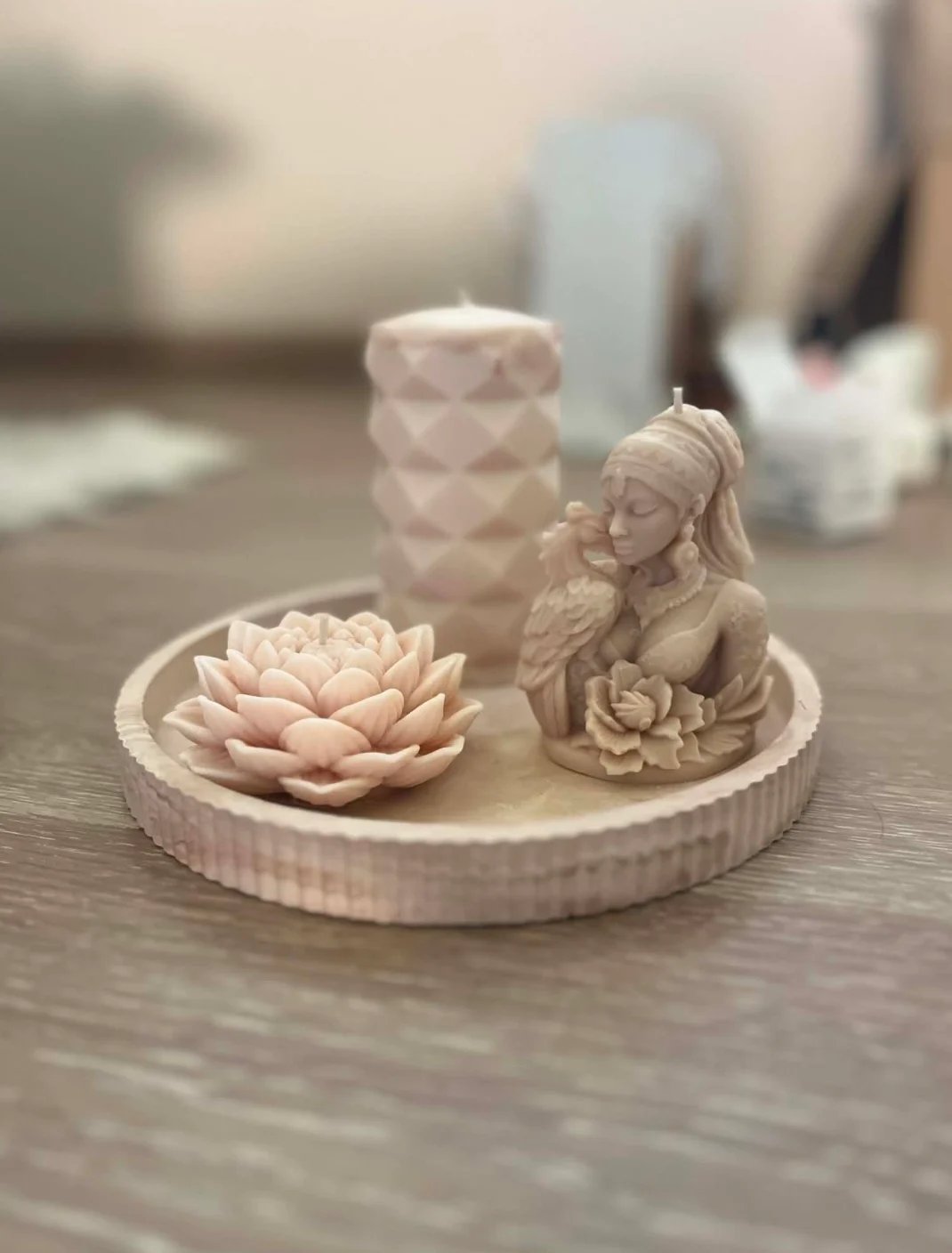 Decorative cream-colored candle holder set with lotus flower sculpture and Buddha figurine on round ridged dish