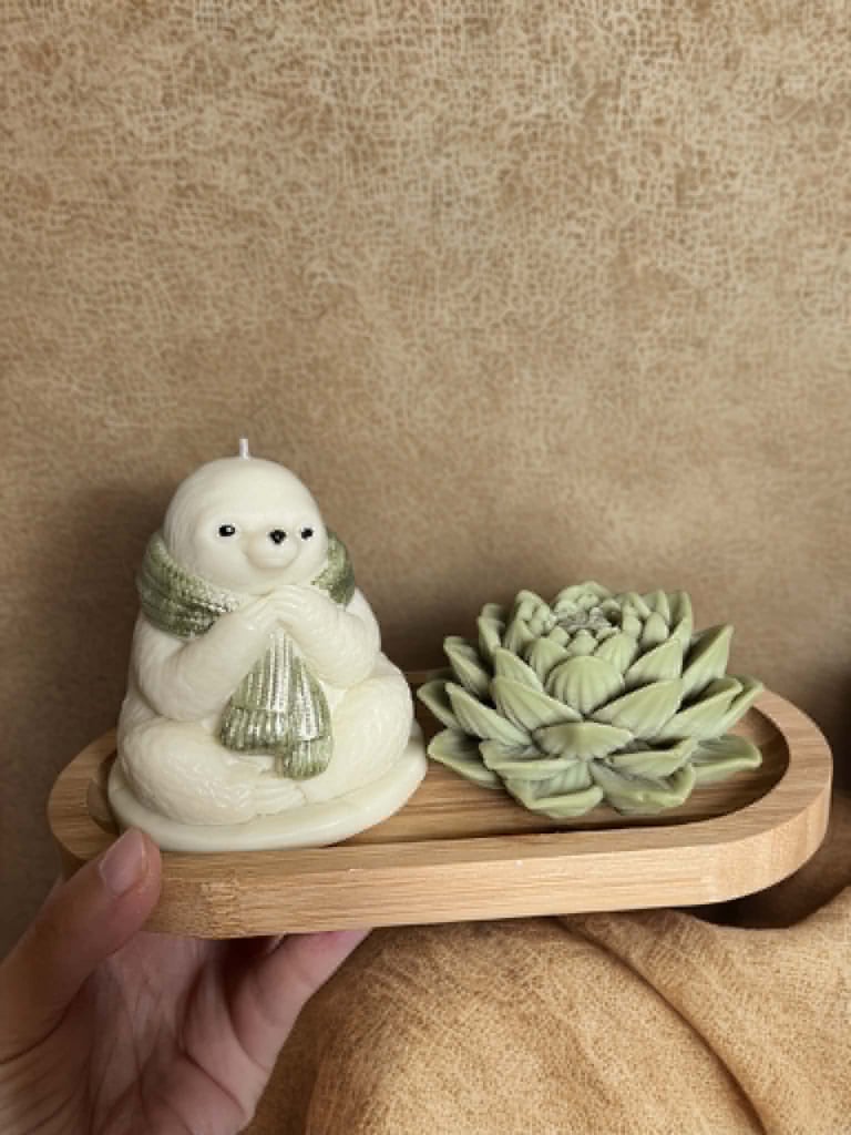 Hand holding a wooden planter with a white snowman figurine wearing a green scarf and a small succulent plant
