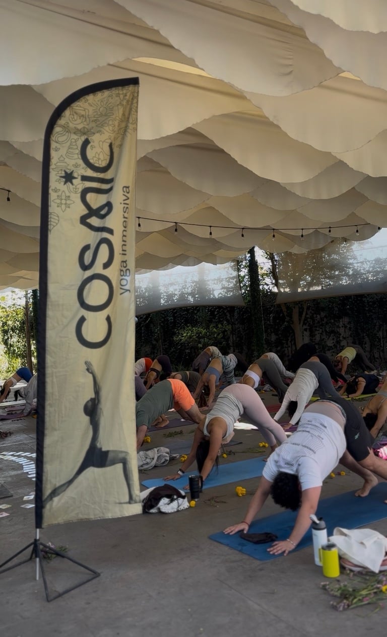 Group of people practicing yoga under a beige fabric canopy with a Cosya branded banner displayed