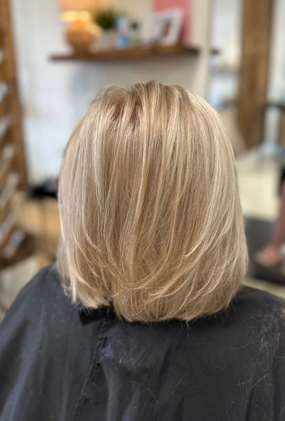 Back view of a shoulder-length blonde-highlighted cut with straight layers.