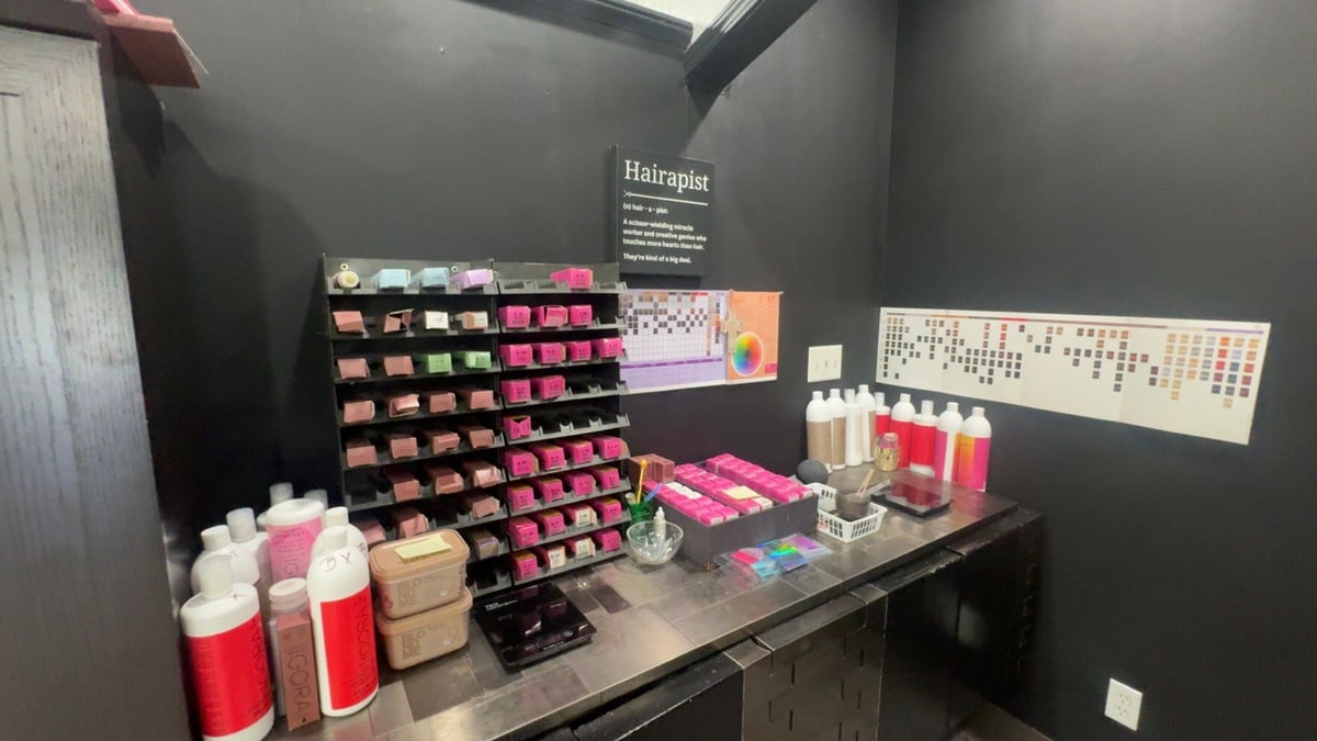 Color samples and professional haircare products displayed on shelves in a consultation area