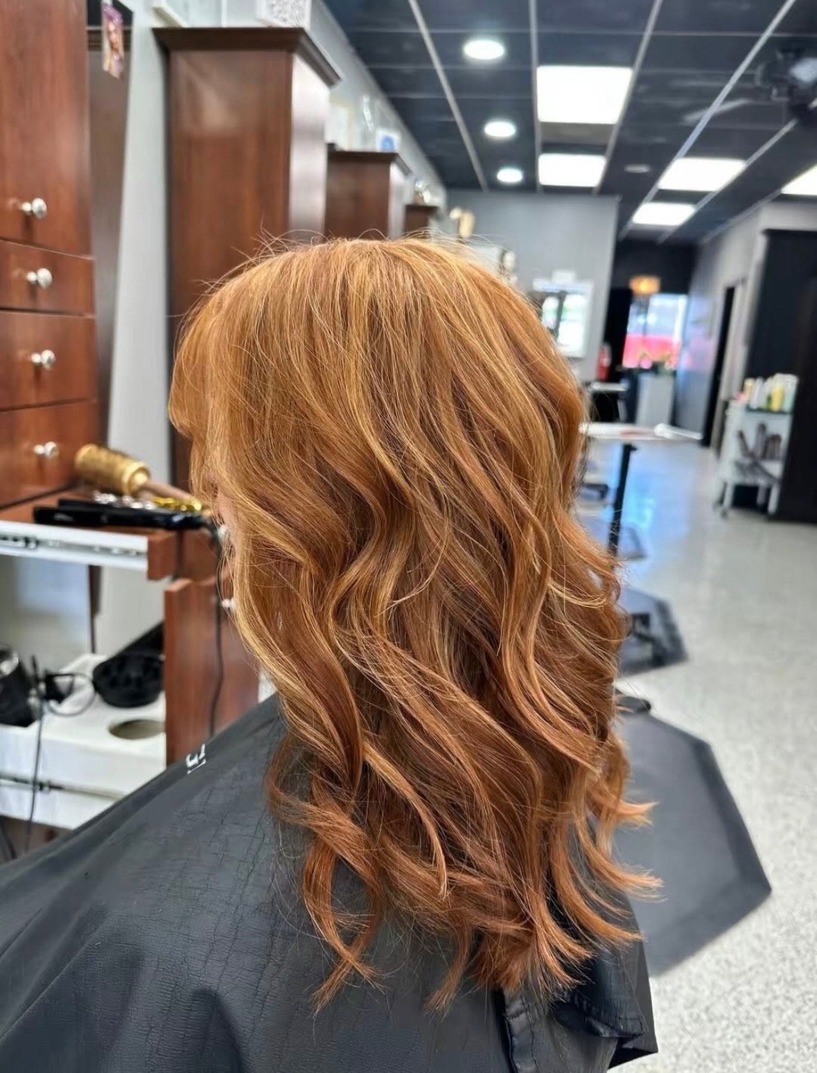 Back view of long, wavy, copper-blonde hair in the salon.