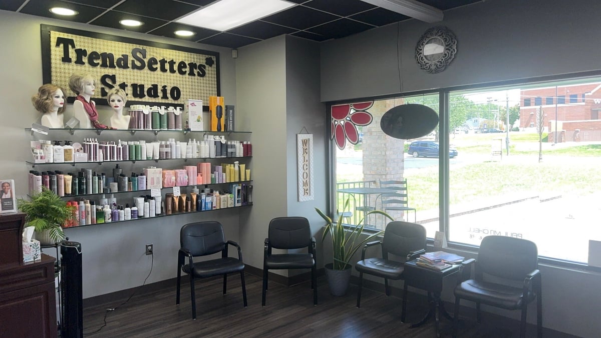 TrendSetters Studio waiting area with product shelves, black chairs, and large windows overlooking the parking lot