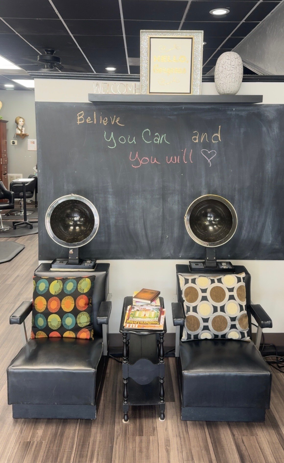 Spa pedicure station with two massage chairs, heat lamps and a chalkboard reading 'Believe You Can and You will'