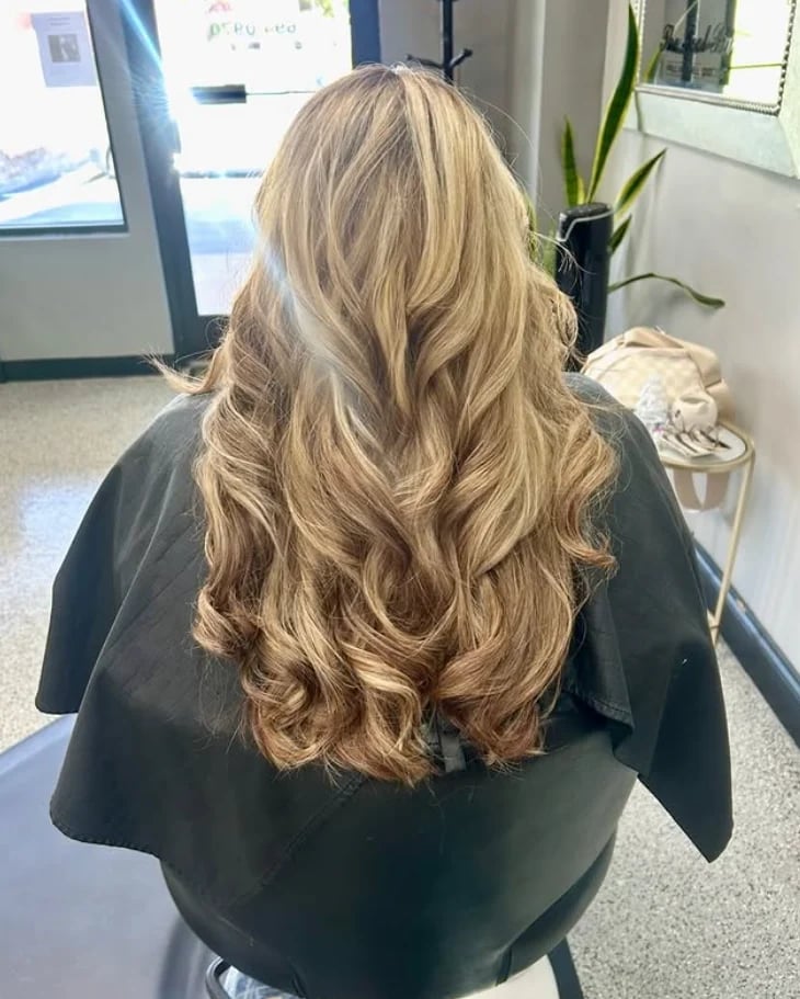 Back view of long, wavy blonde hair in the salon.