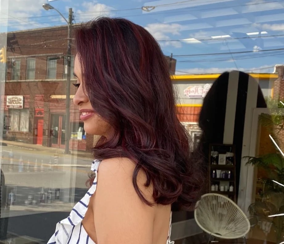Side view of a long, rich burgundy hair color shown in natural light.