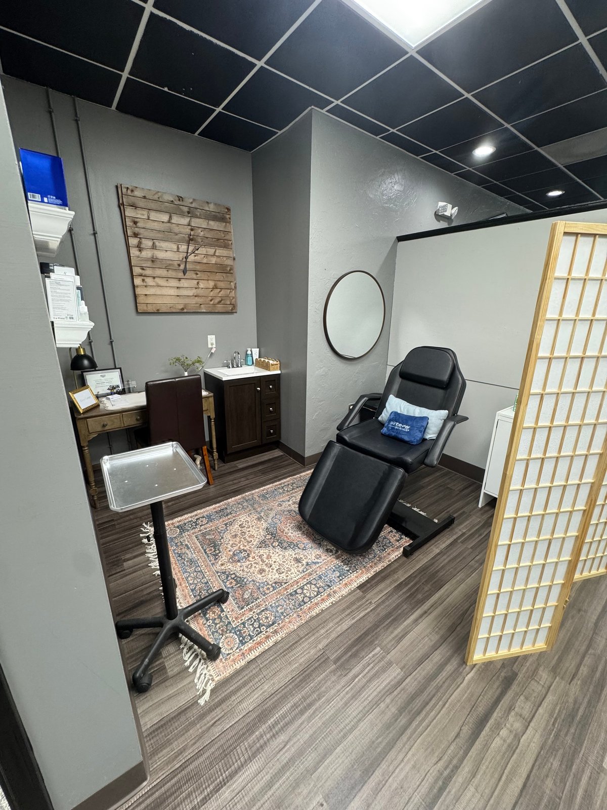 Private treatment room with aesthetic massage chair and wood vanity