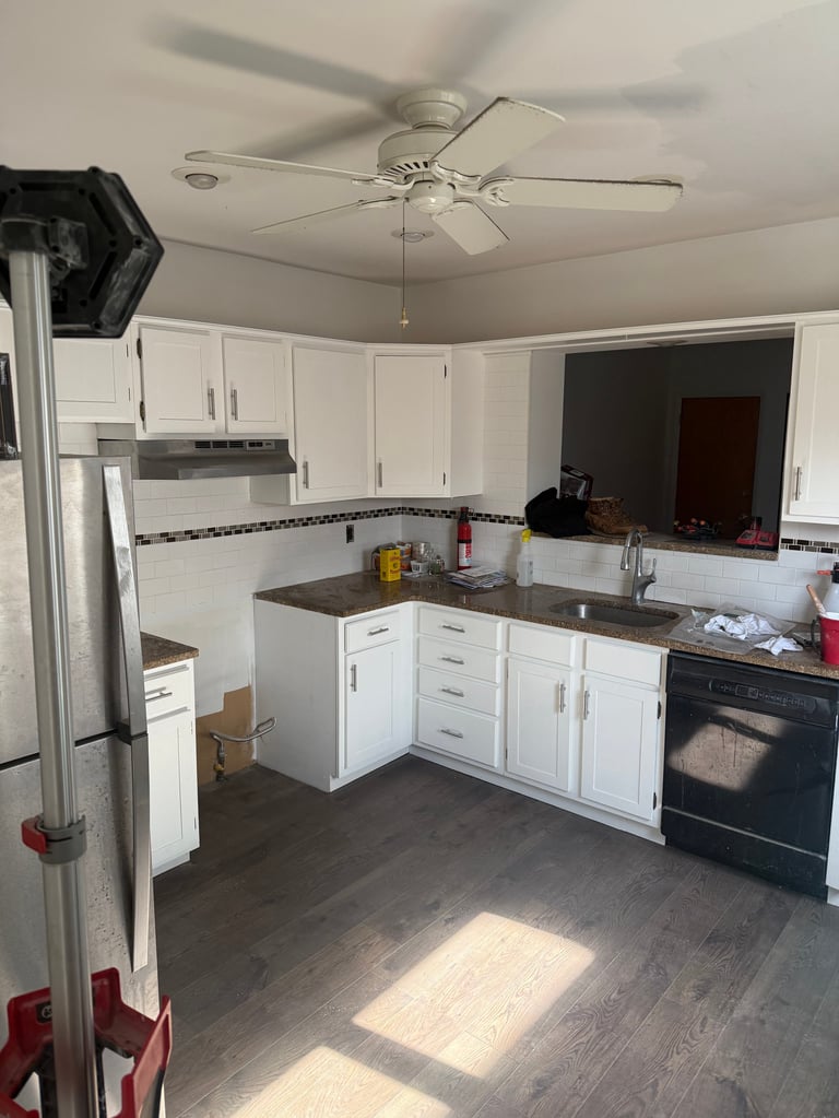 Kitchen with white cabinets, dark countertops, stainless steel appliances, and ceiling fan