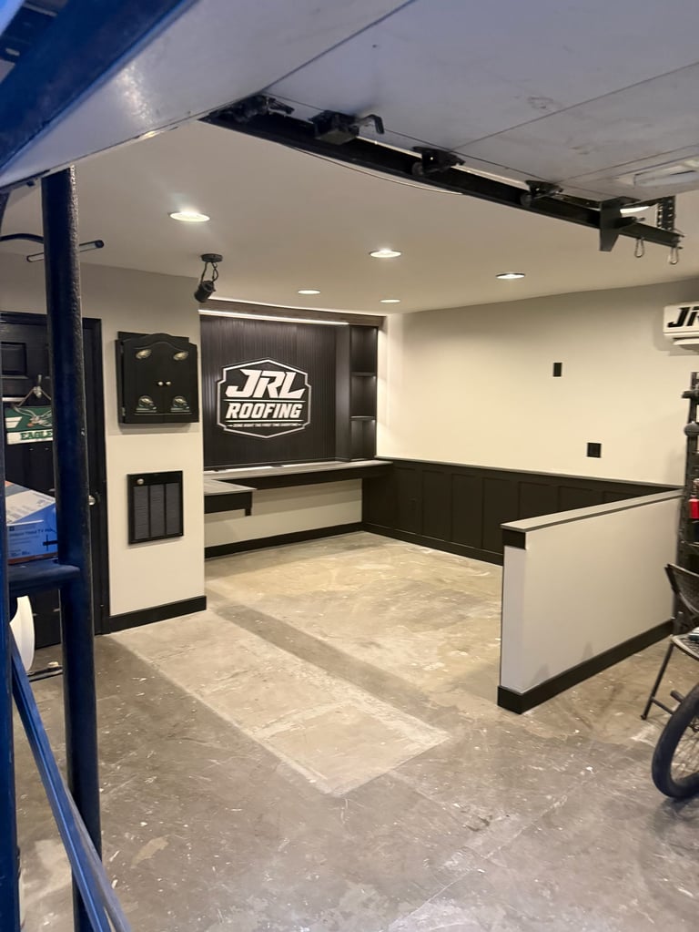 Interior of a mobile office or trailer for JRL Roofing with white walls, black countertop, tile flooring, and recessed lighting