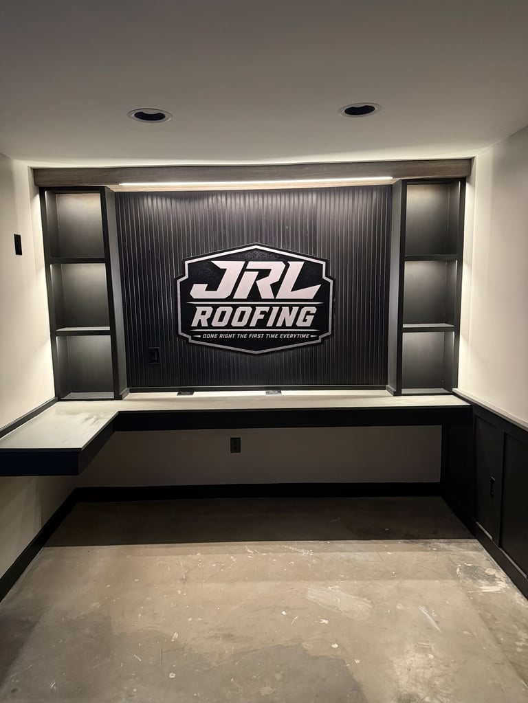 Modern showroom interior with JRL Roofing logo displayed on dark corrugated wall panel, flanked by shelving units