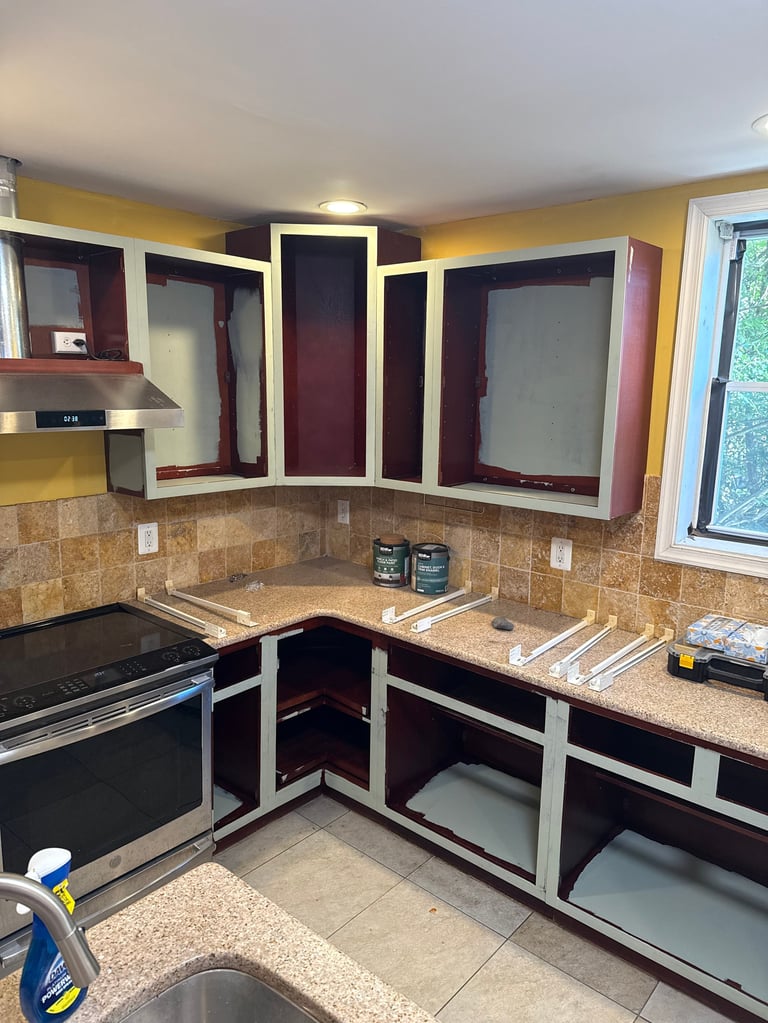 Modern kitchen with burgundy and cream cabinets, granite countertops, tile backsplash, yellow walls, and stainless steel appliances
