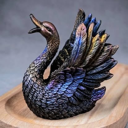 Decorative black peacock figurine with iridescent blue and gold feathers on a wooden base