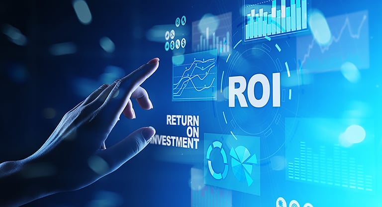 Hand holding a pen near holographic ROI and financial charts on a blue digital background representing return on investment analytics