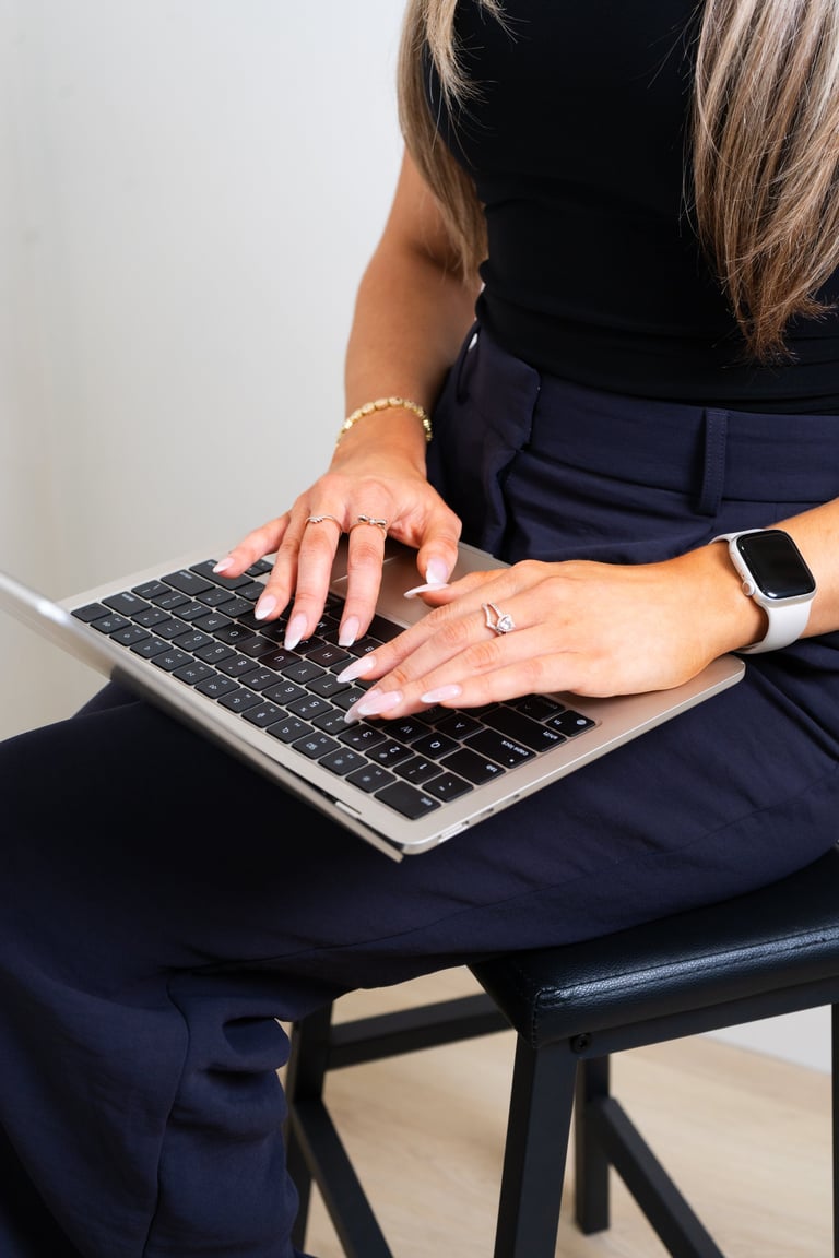 Close-up of Victoria's hands working on a laptop keyboard
