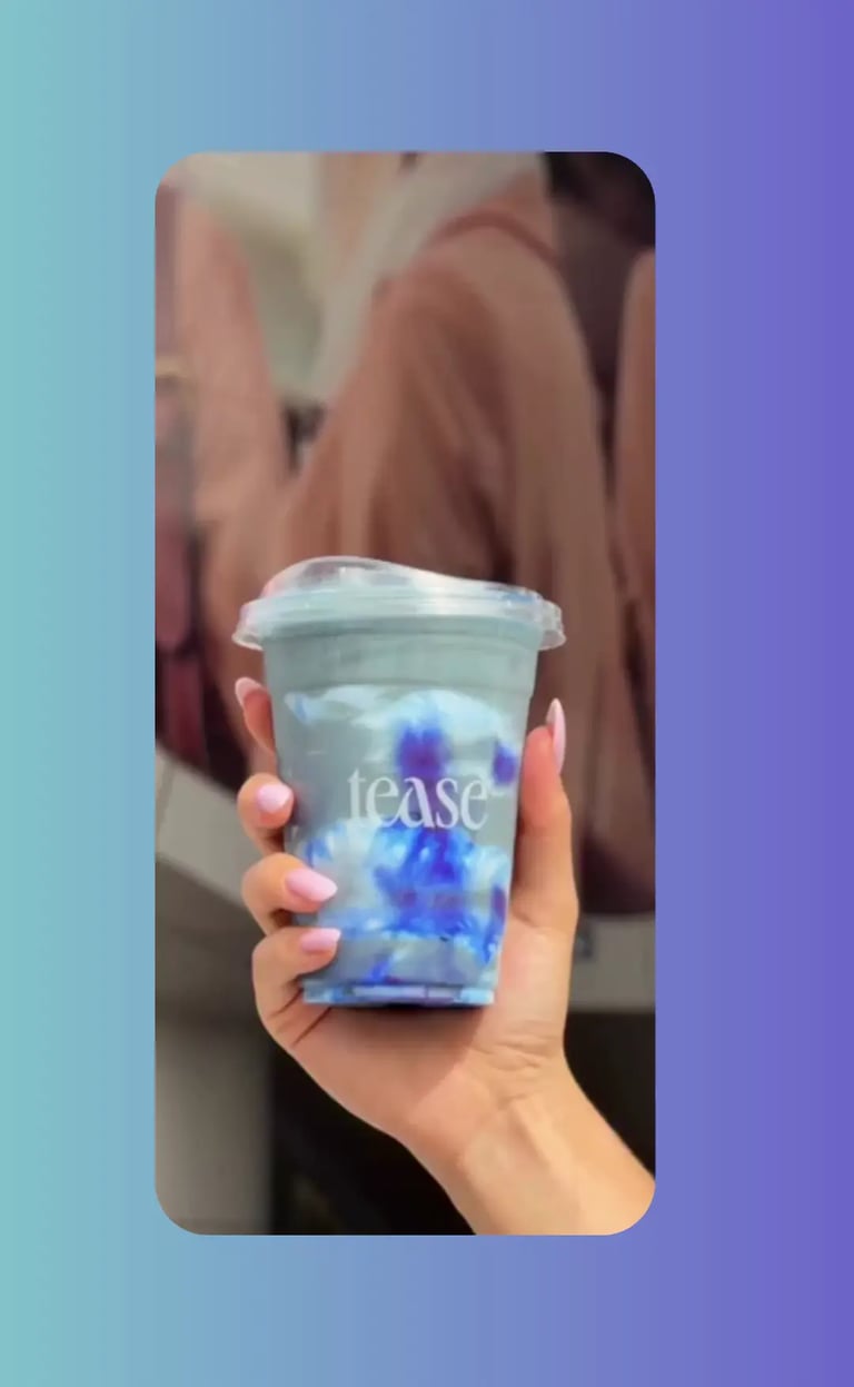 Video reel of a hand holding a clear Tease bubble tea cup with butterfly pea flowers and iced blue tea