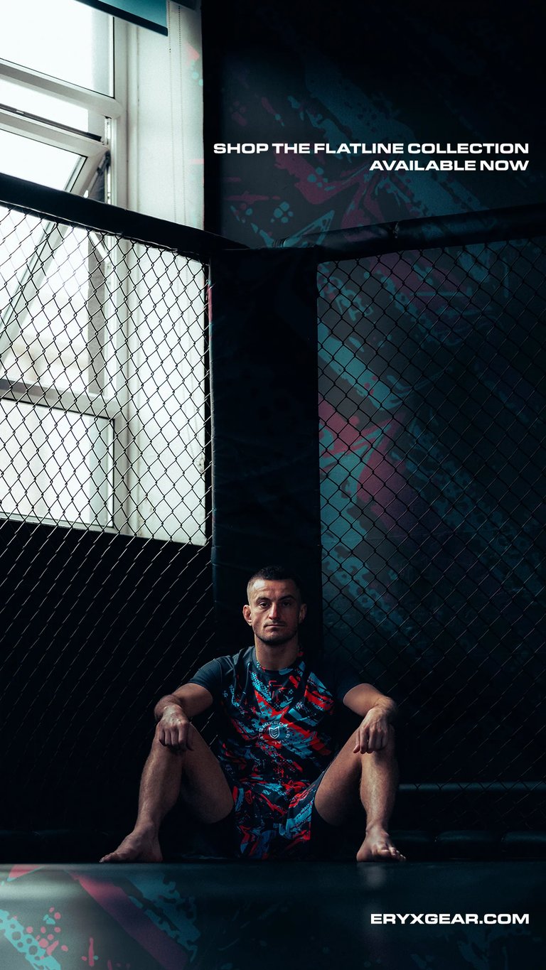 Man sitting in dark industrial space wearing colorful patterned shirt, promotional image for Flatline Collection at ERYX GEAR