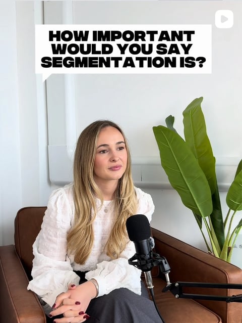 Woman speaking into microphone with text asking How important would you say segmentation is? A green plant is visible in the background