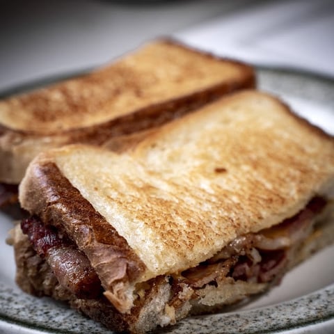 Two toasted cinnamon-sugar coated bread slices stacked on a gray plate, with chocolate filling visible between layers