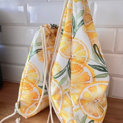 Drawstring bag with lemon slice print in yellow and green on white fabric