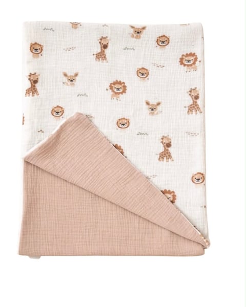 Folded baby blanket with animal print pattern in cream and beige colors, featuring lions, giraffes and other animals