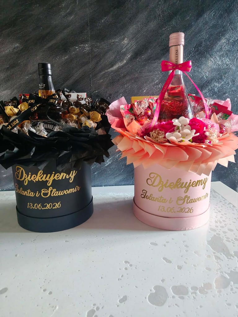 Dwa dekoracyjne flowerboxy: czarny ze złotymi czekoladkami oraz różowy z kwiatami i różową wstążką — Podziękowanie Jolanta i Sławomir 13.06.2026