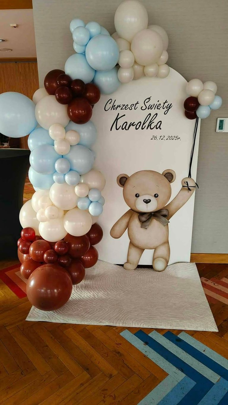 Ścianka Chrzest Święty Karolka 20.12.2025r z brązowym, niebieskim i kremowym łukiem balonowym oraz dużą planszą z brązowym misiem i napisem