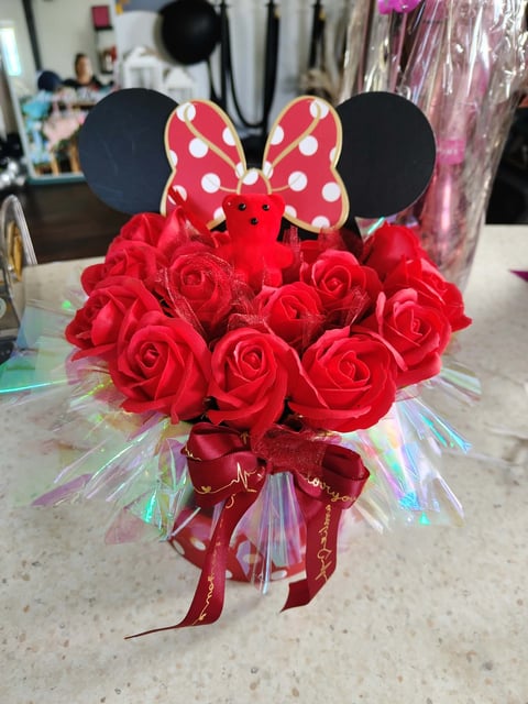 Minnie Mouse-themed bouquet of red roses with polka dot bow and mickey ear toppers tied with red ribbon