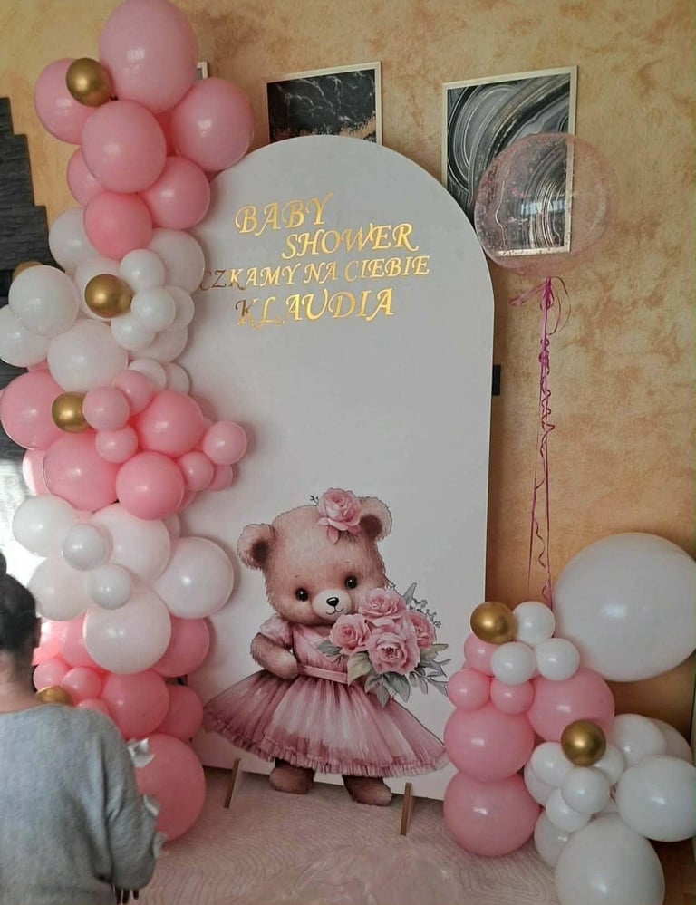 Ścianka Baby Shower Czekamy na Ciebie Klaudia z różowo-biało-złotym łukiem balonowym i brązowym misiem w różowej sukience