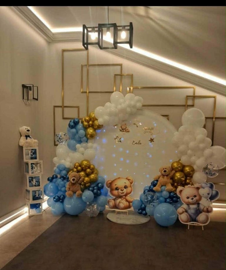 Ścianka baby shower z brązowymi misiami, złoto-niebieskimi balonami, białymi chmurkami, złotymi ramkami oraz podpisem Welcome Little One