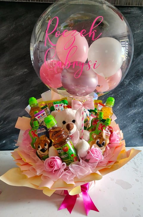 Decorative gift bouquet with clear bubble balloon containing pink and white balloons, teddy bears, candy, and pink roses with pink ribbon bow