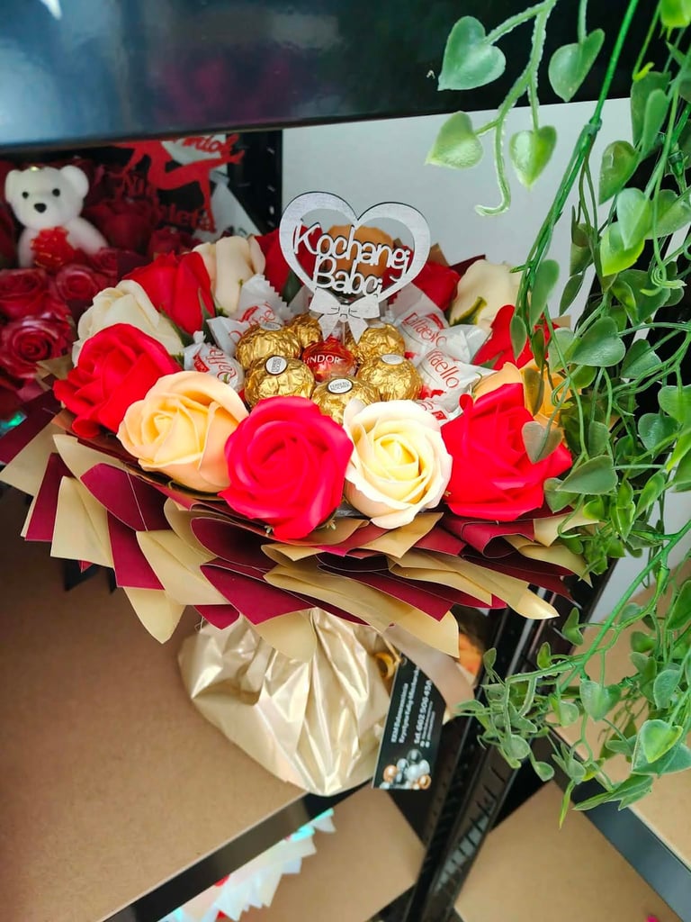 Romantyczny bukiet z czerwonych i kremowych róż, złotych Ferrero Rocher, otoczony zielonym bluszczem, z drewnianym sercem Kochanej Babci w środku
