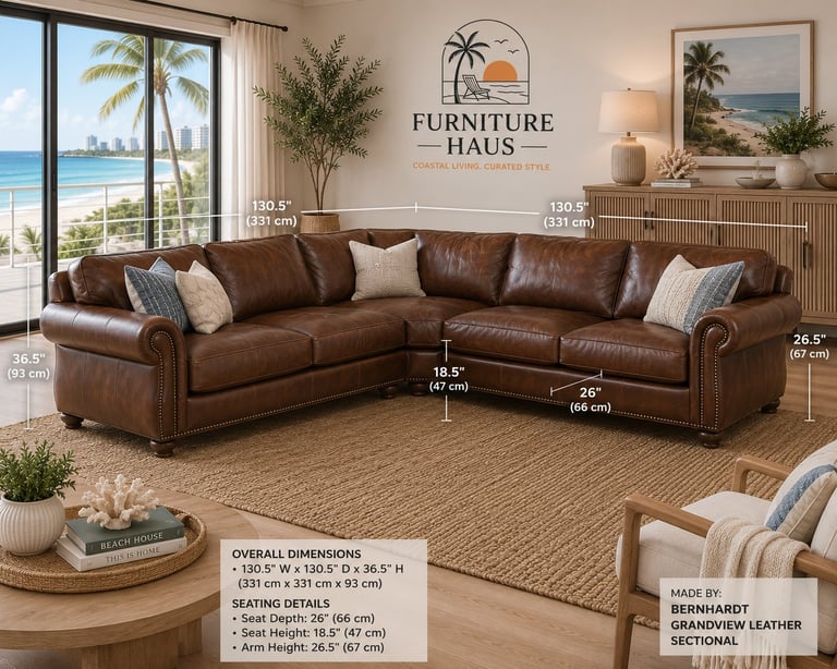 Brown leather sectional sofa with rolled arms and nailhead trim in bright coastal living room with ocean view