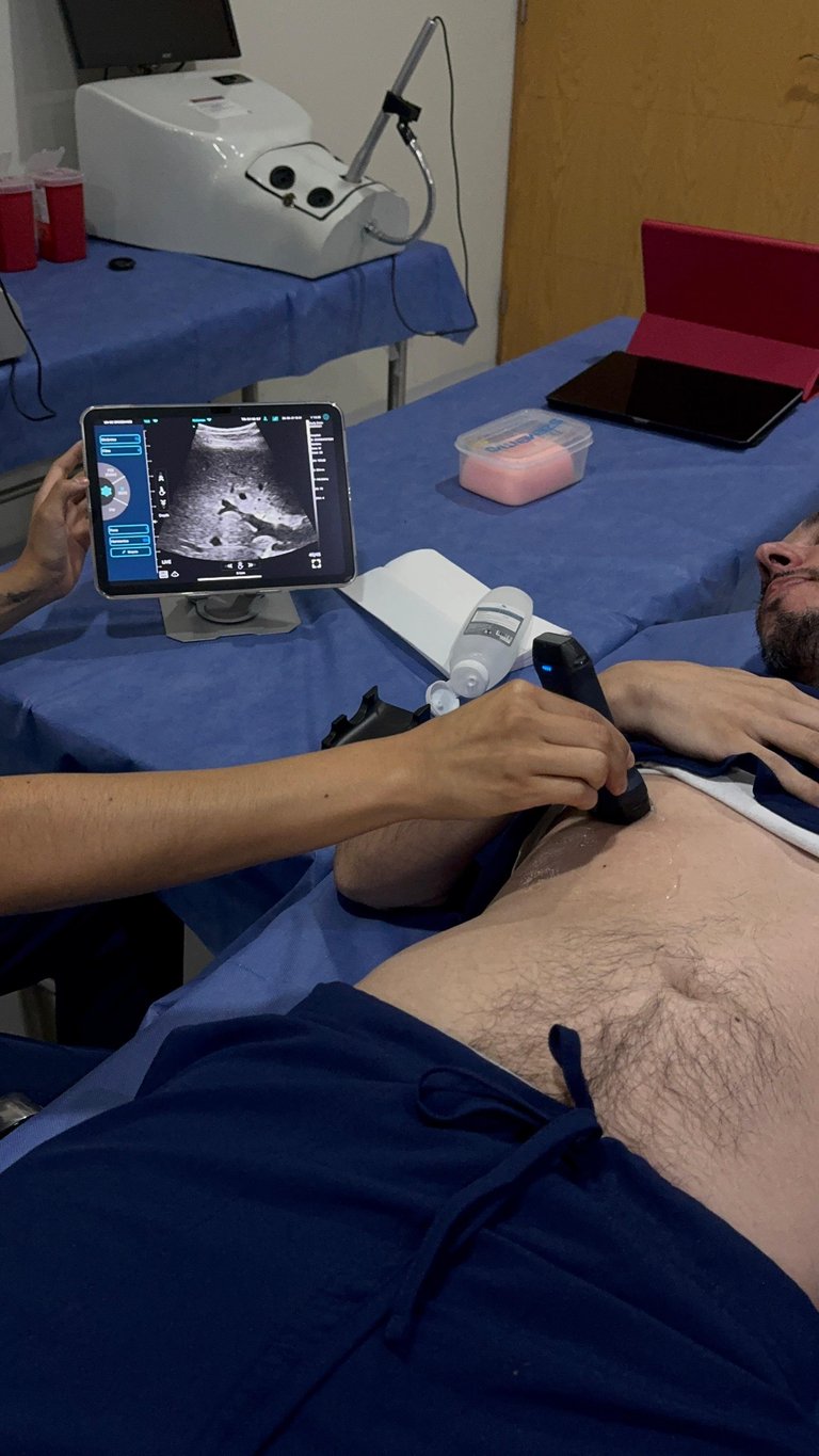 Técnico sosteniendo sonda de ultrasonido mientras visualiza imagen en tablet durante examen