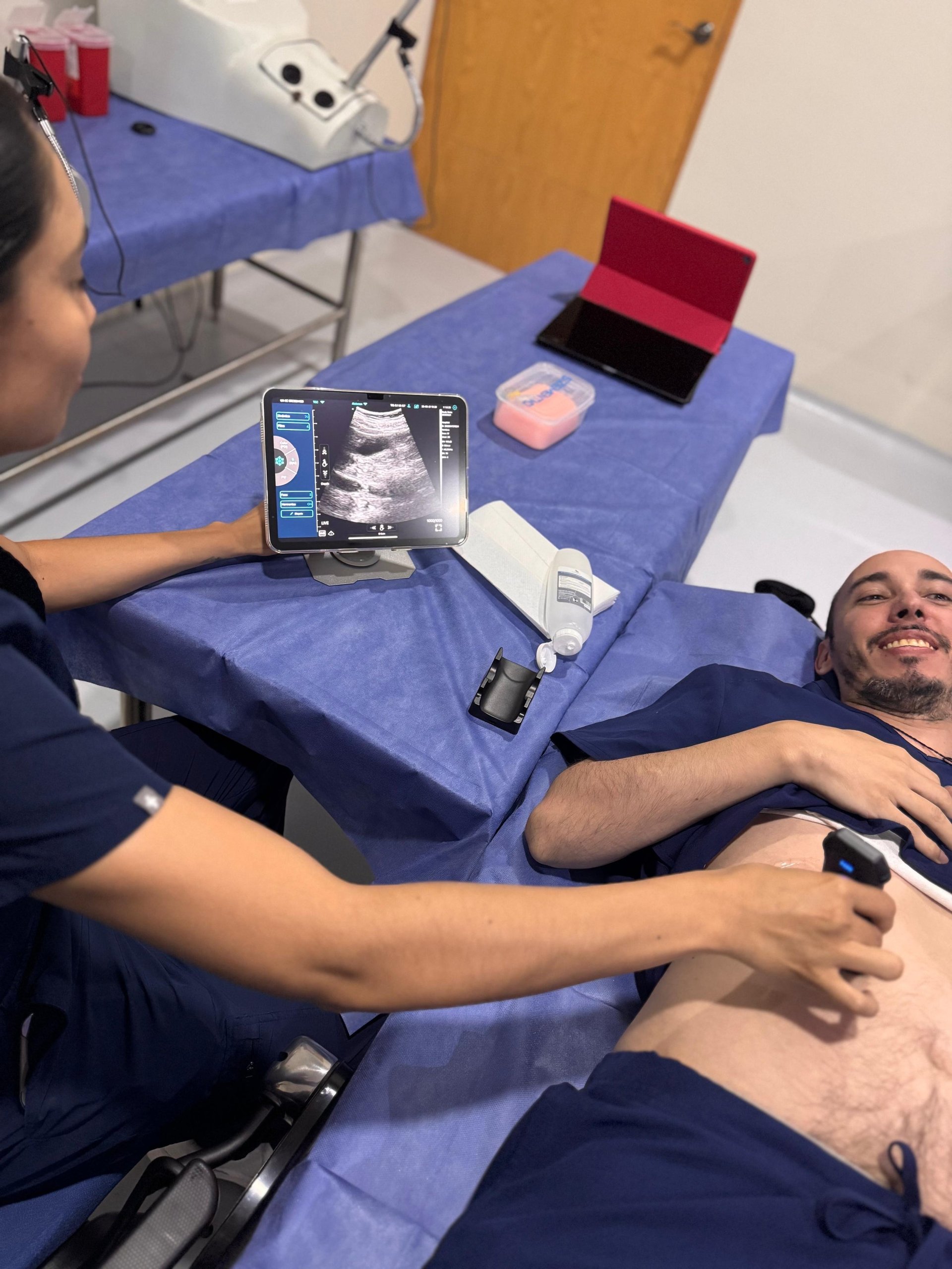 Profesional de salud realizando ultrasonido abdominal con dispositivo portátil