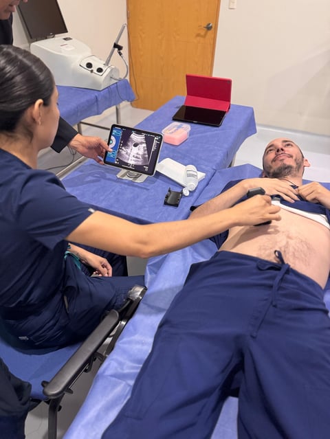 Profesional médico realizando ultrasonido abdominal a paciente acostado con dispositivo portátil MY11