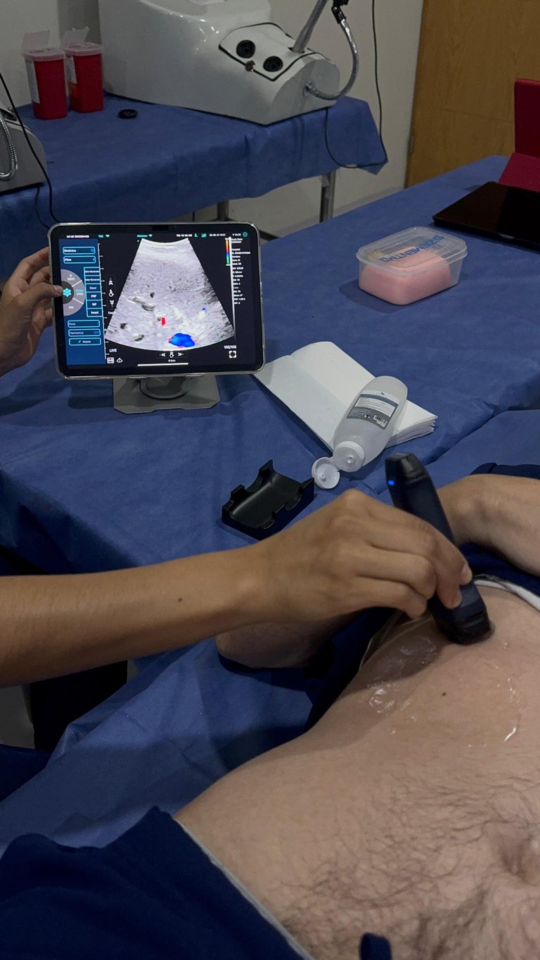 Profesional médico realizando escaneo de ultrasonido con dispositivo portátil y tablet