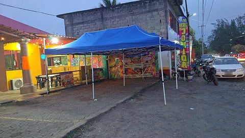 Restaurante con carpa azul de Moloshop al atardecer en una esquina