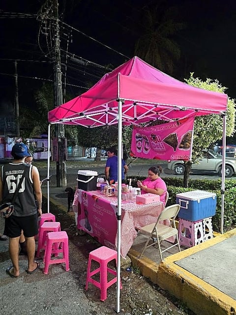 Carpa rosa de Moloshop en un puesto de comida nocturno atendido por sus dueños