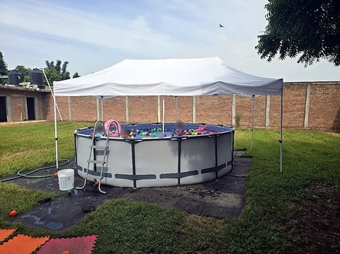 Carpa blanca de Moloshop cubriendo una fiesta familiar junto a la alberca