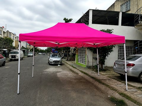 Carpa fucsia de Moloshop armada sobre la banqueta junto a la calle